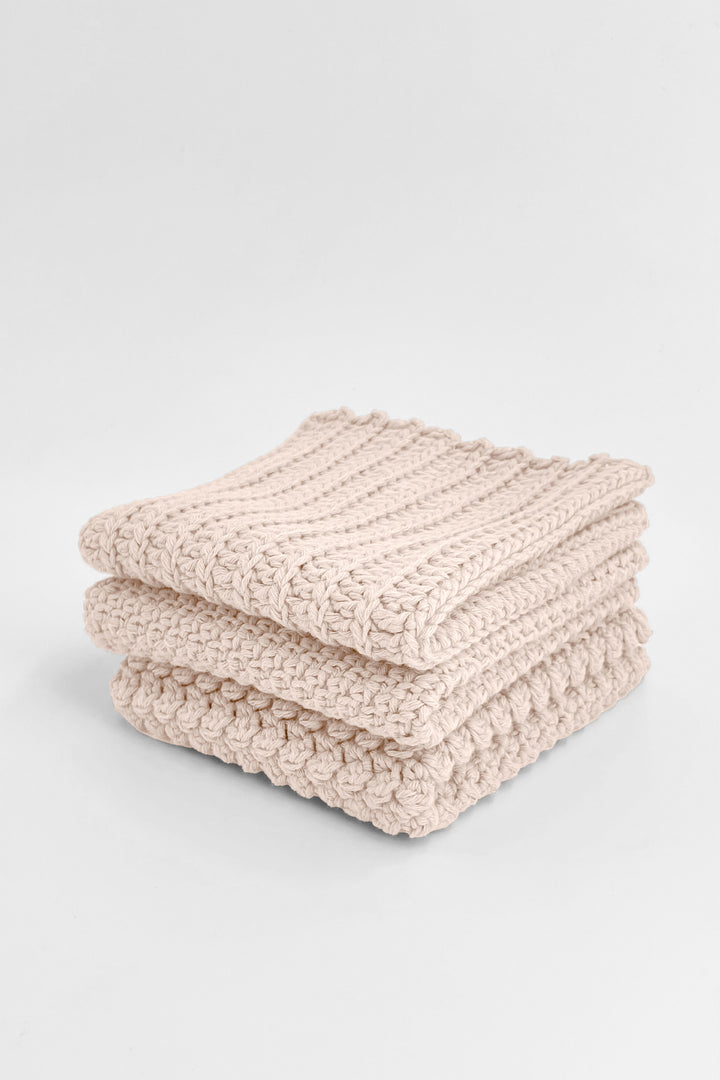 Stack of beige  textured towels on a light gray background