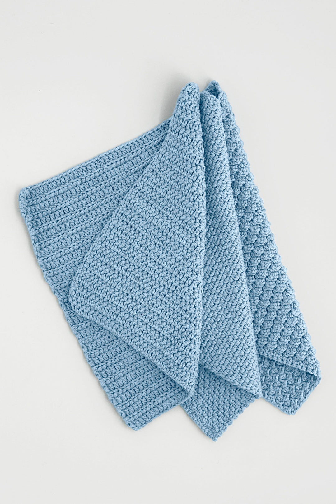 Blue crochet towels on a light gray background