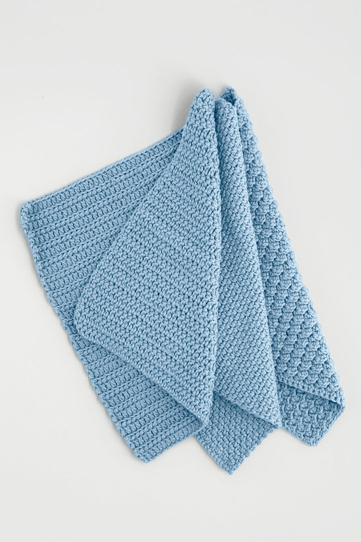 Blue crochet towels on a light gray background