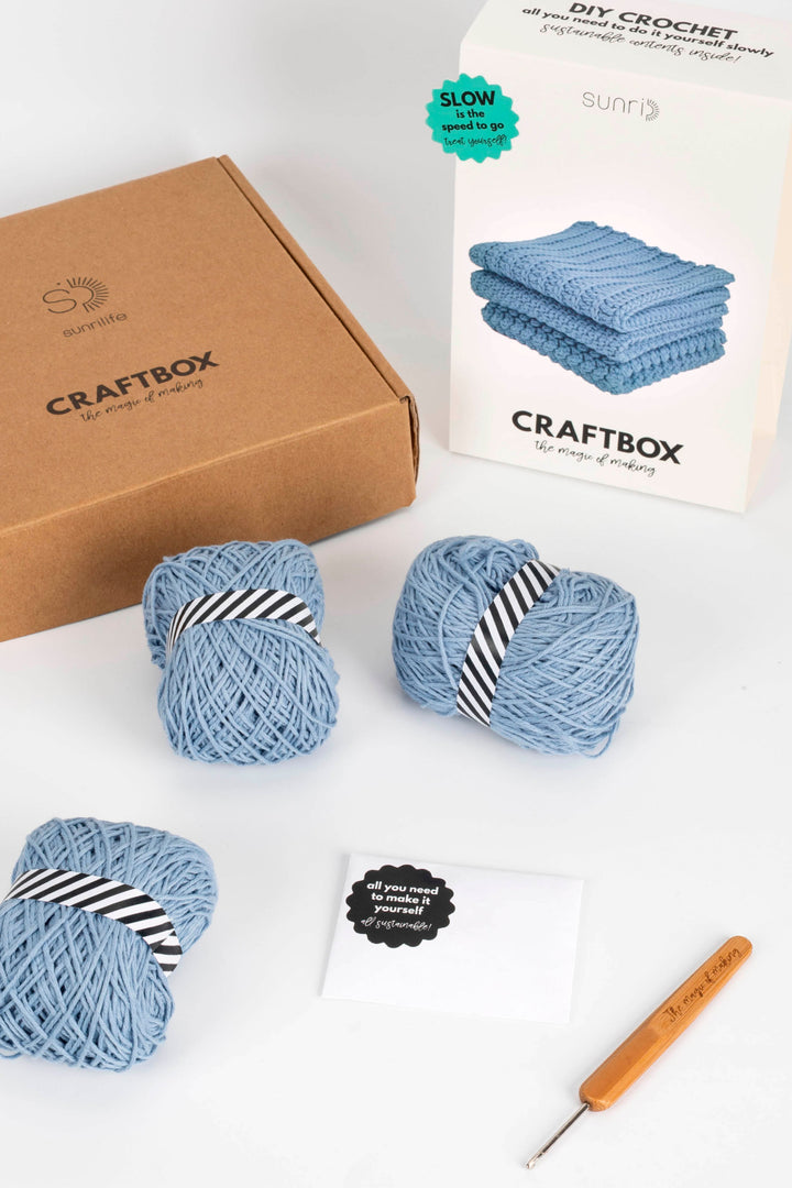 Craftbox with yarn and crochet hook on a white background