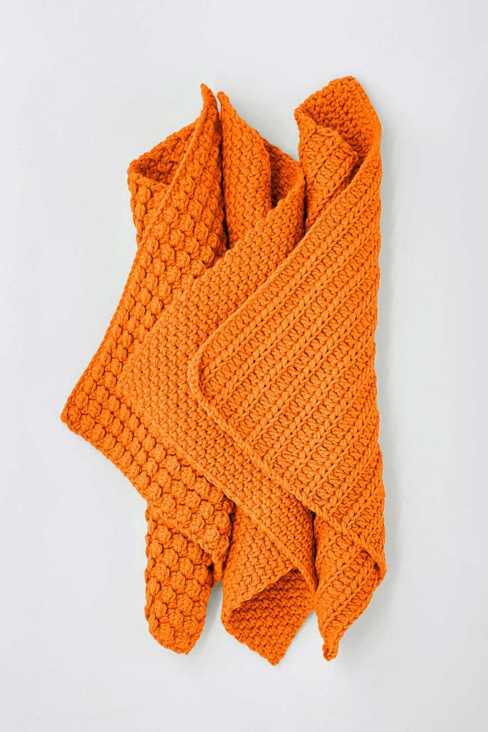 Orange knitted towels on a light gray background