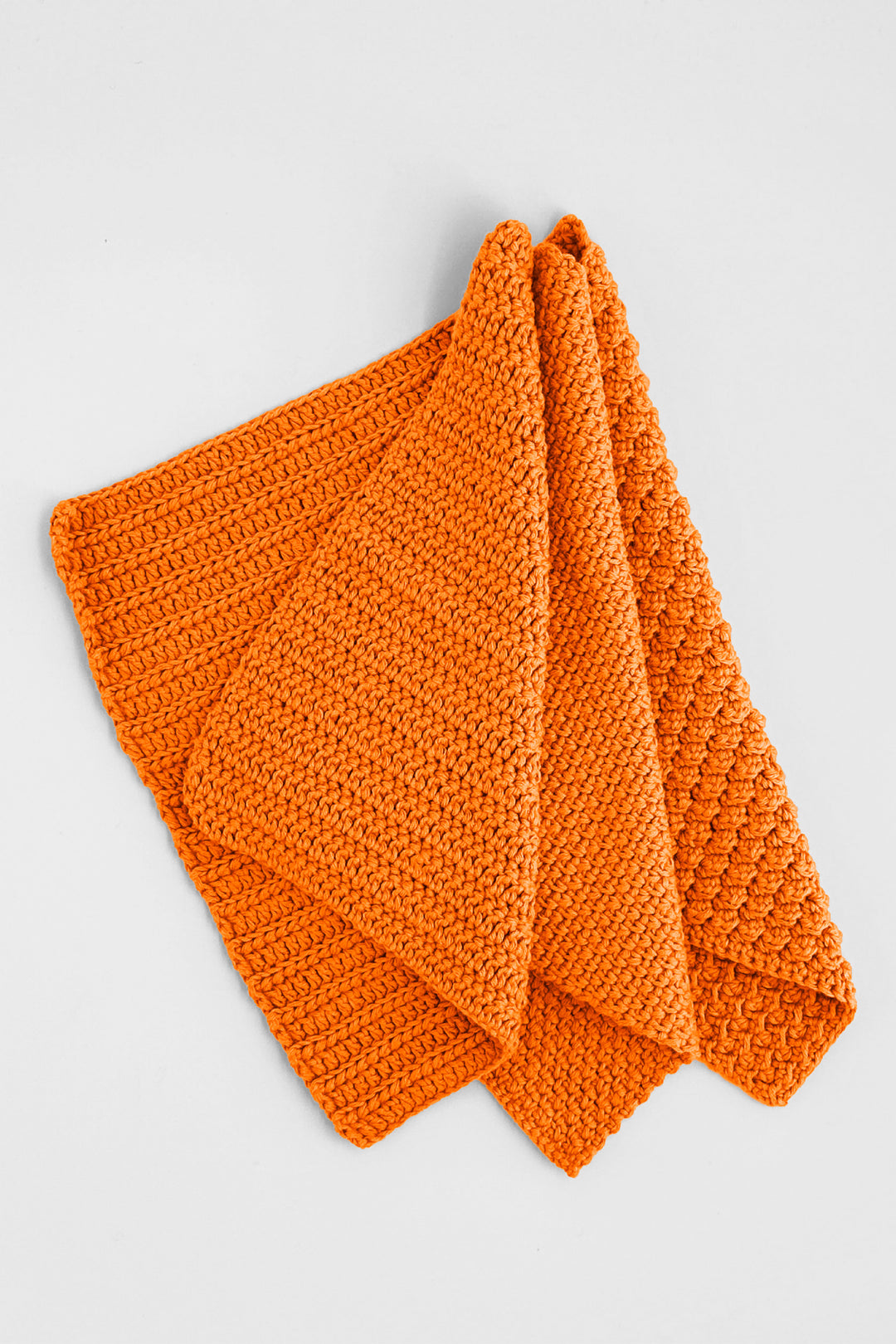 Orange crochet towels on a light gray background