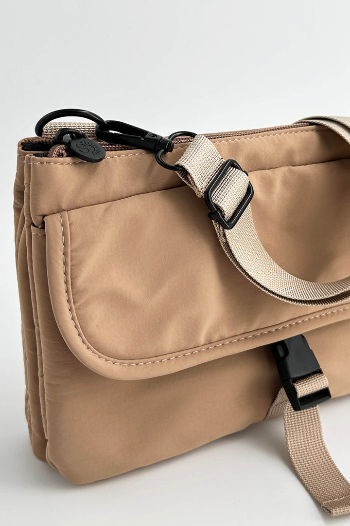 Beige shoulder bag with a strap on a light gray background