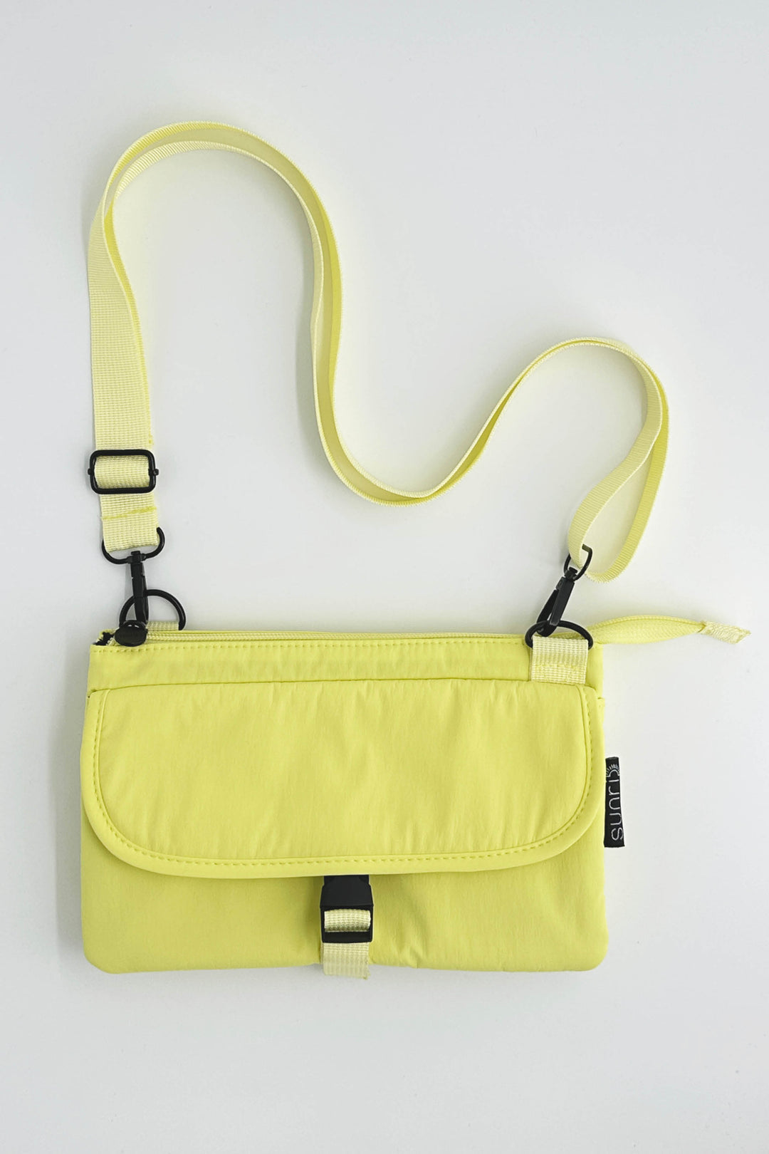 Yellow crossbody bag with adjustable strap on a white background