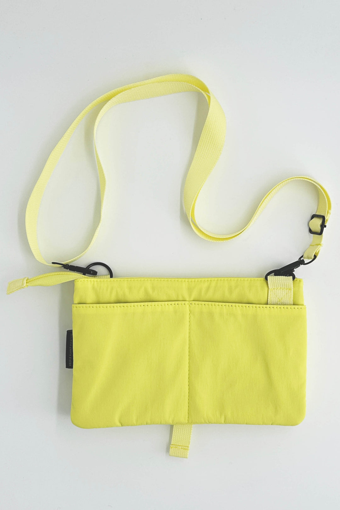 Yellow crossbody bag with a strap on a light gray background