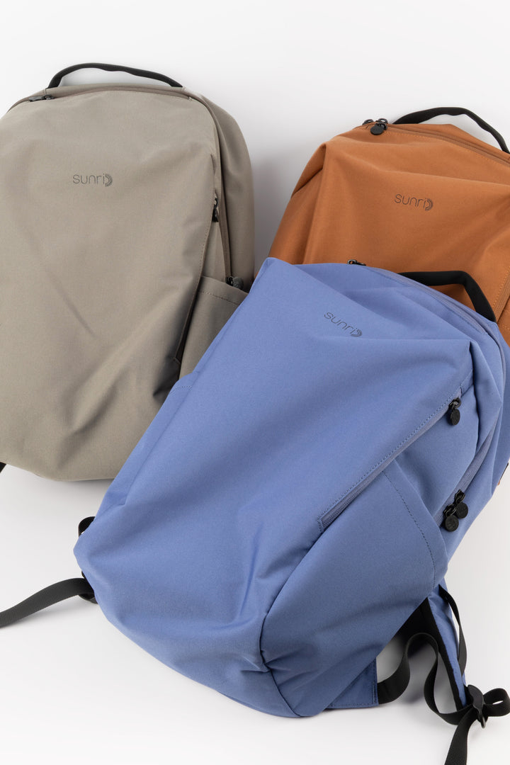 blue laptop backpack next to grey and orange colour options
