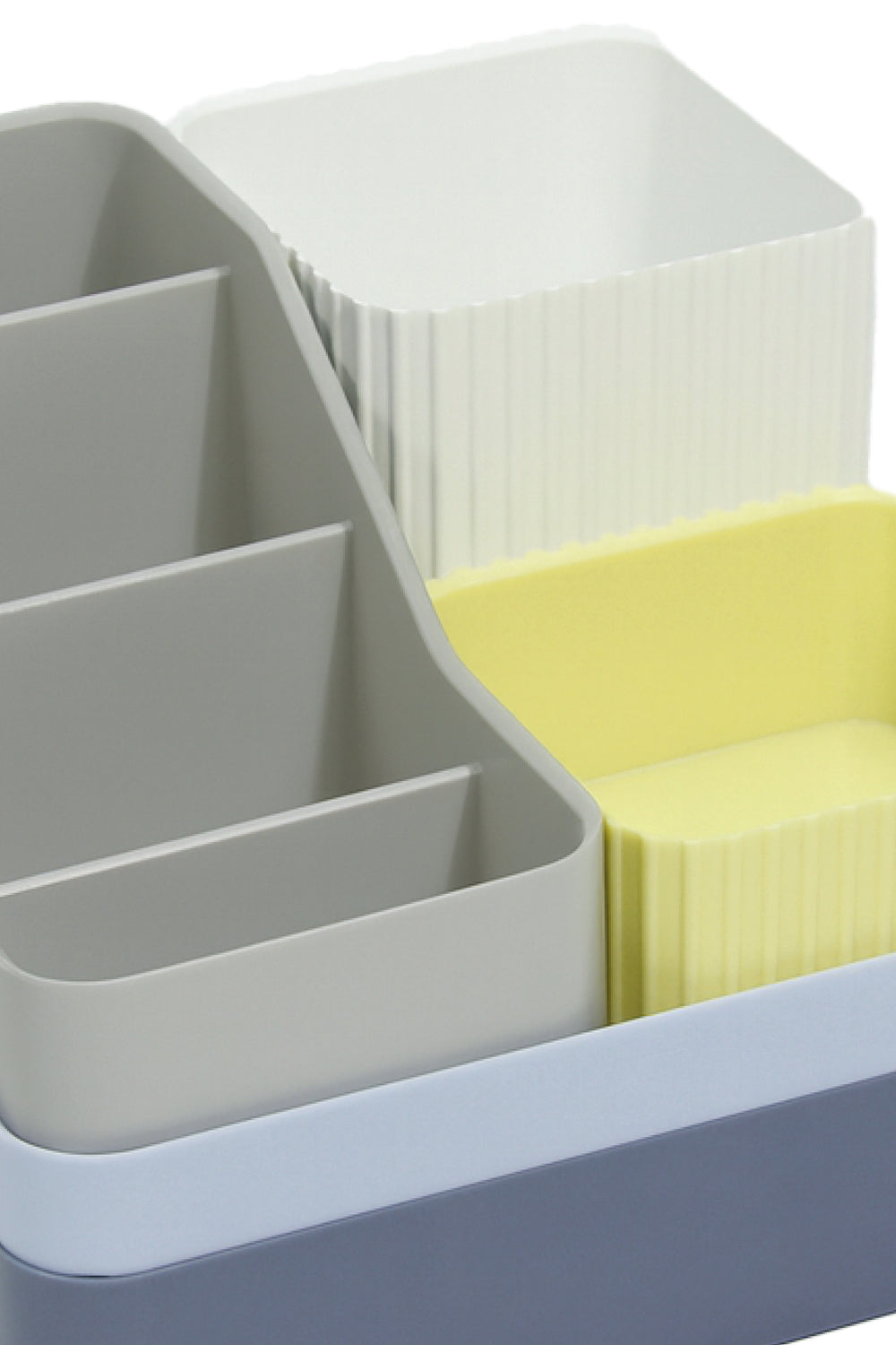 Multicolored desk organiser with compartments holding stationery items.