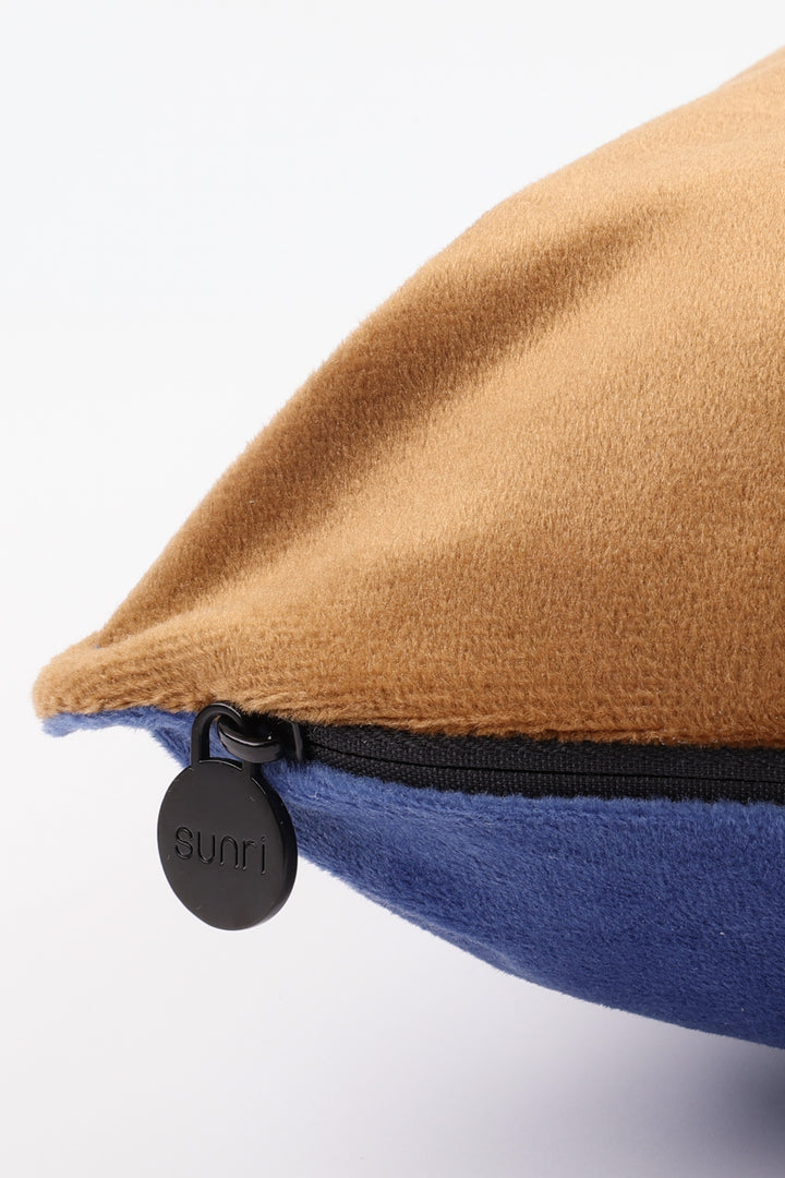 Close-up of a brown and blue fabric product with a black zipper and 'Sunri' label.