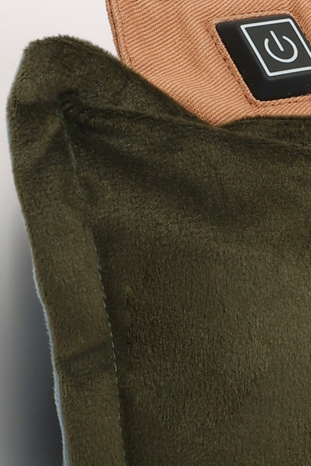 Close-up of a green fabric product with a brown label featuring a power symbol.