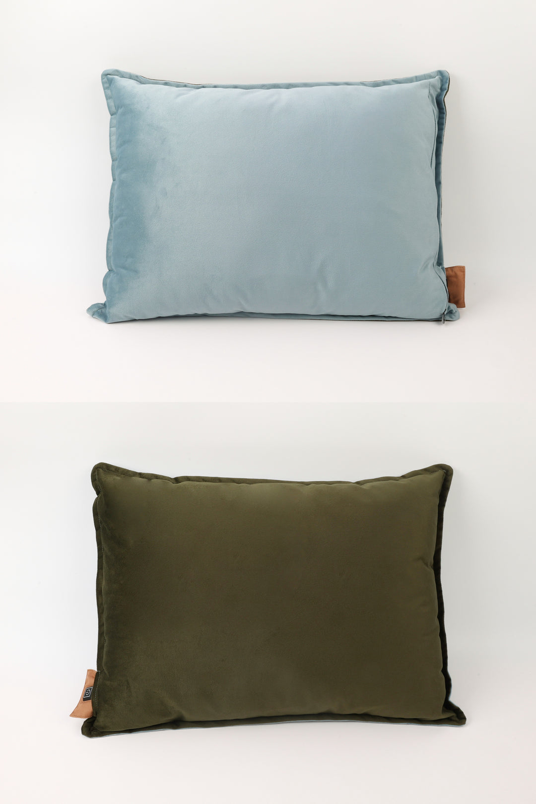 Two pillows, one blue and one green, on a white background