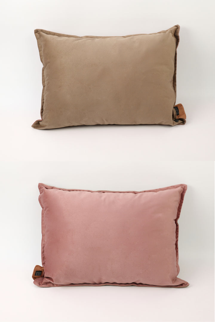 Two pillows, one brown and one pink, on a white background