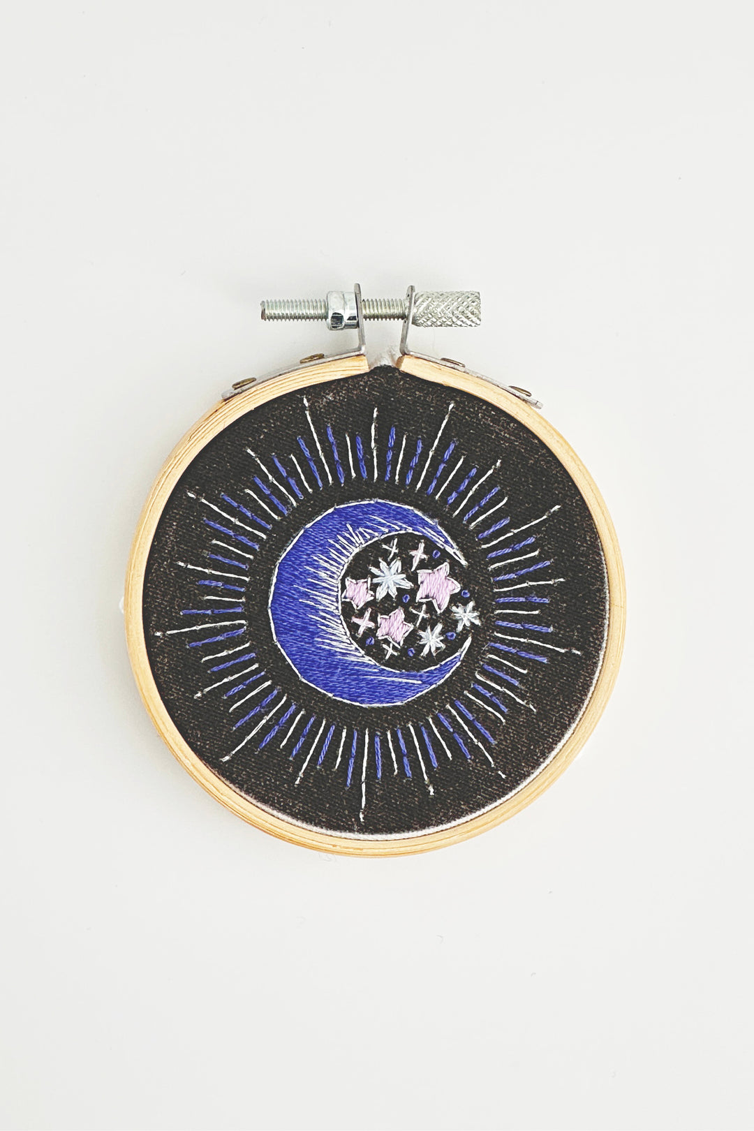 Embroidery hoop with celestial design on a white background