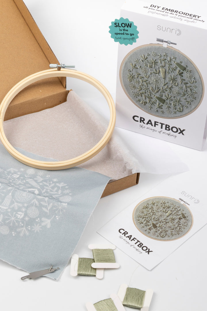 Embroidery hoop and craft materials on a white surface with 'Craftbox' branding.