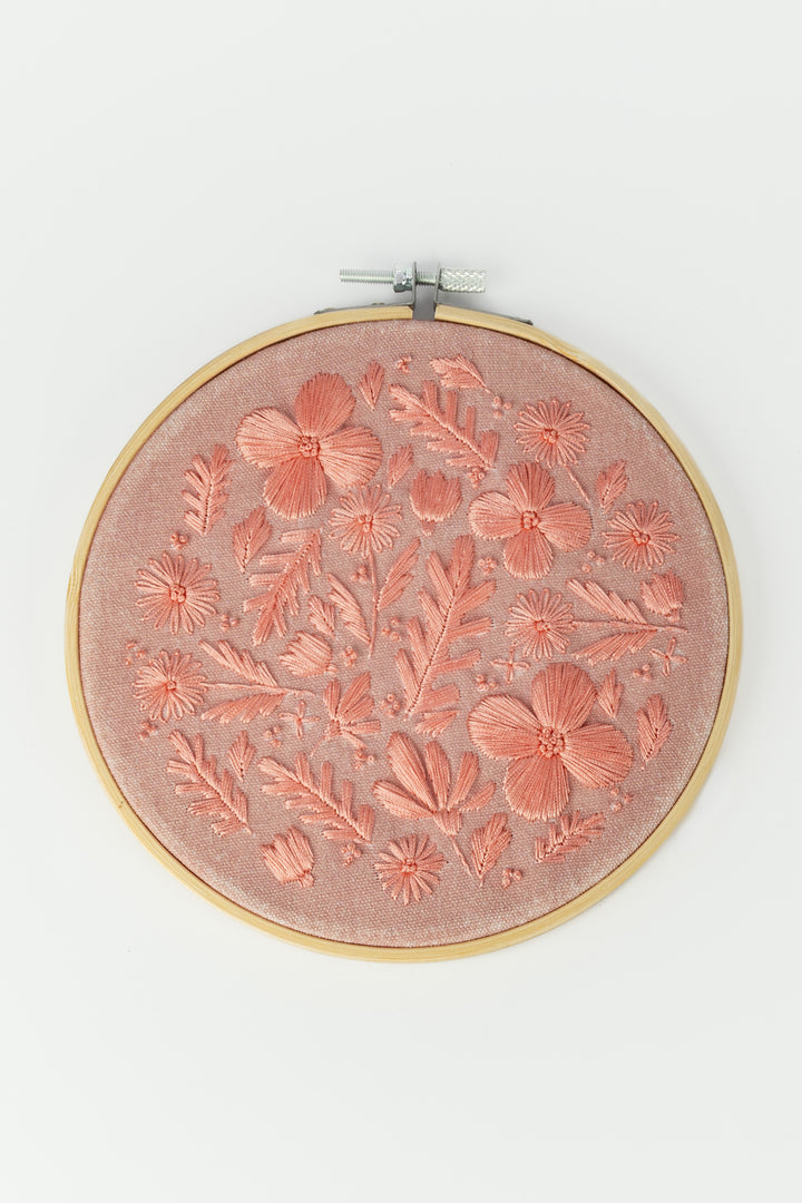 Embroidery hoop with floral pattern on a white background