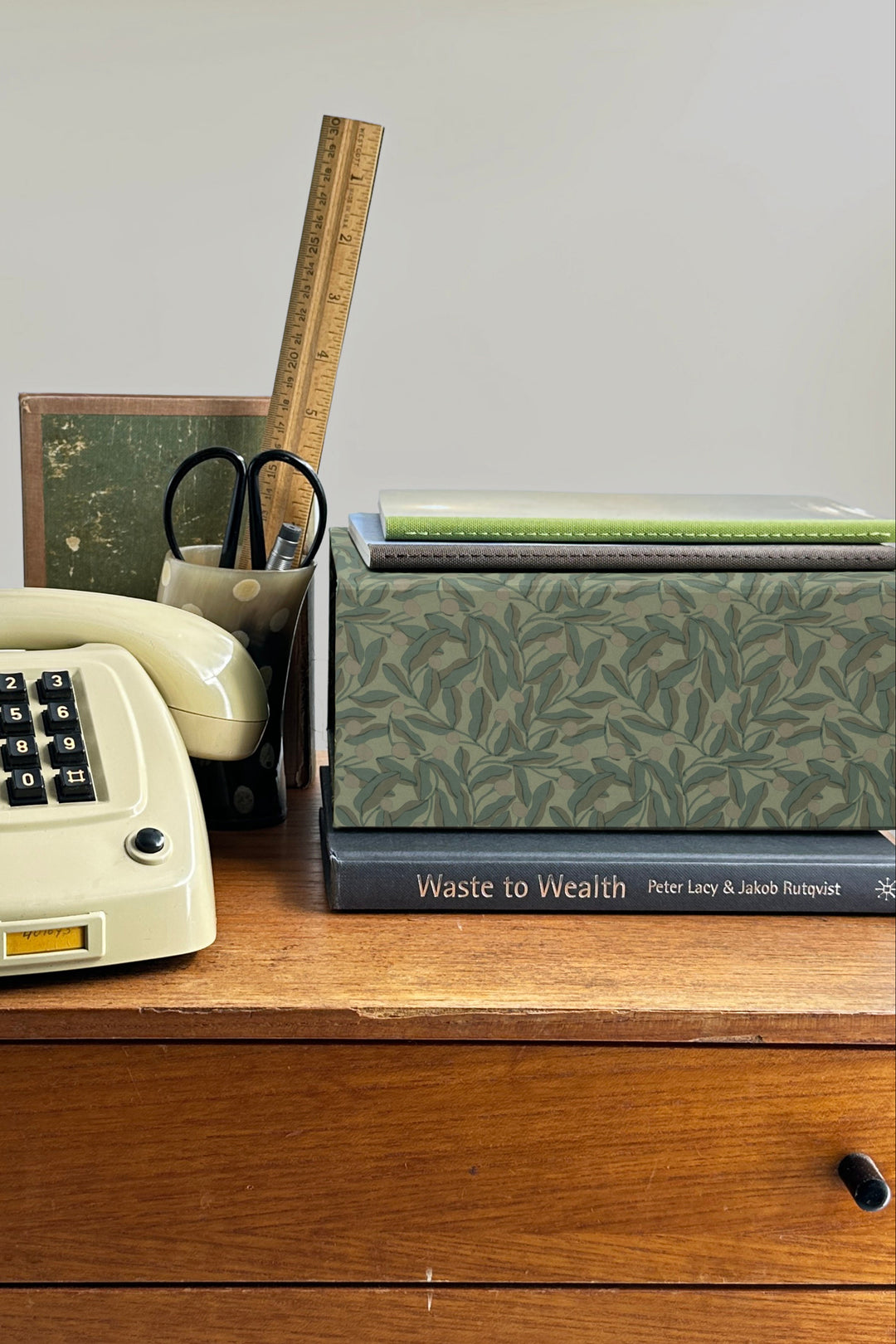 A5 foldable modular desk organiser box in green with berry leaf pattern used as desk storage with notebooks and stationery
