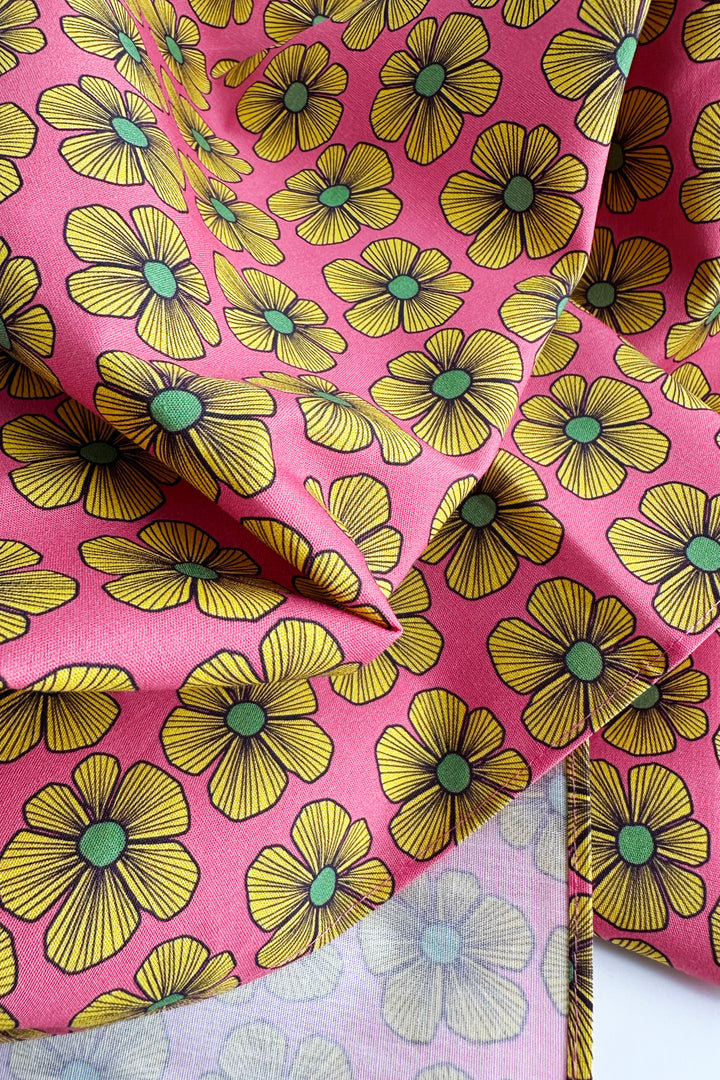 close up of furoshiki wrapping cloth showing pink fabric with yellow floral pattern