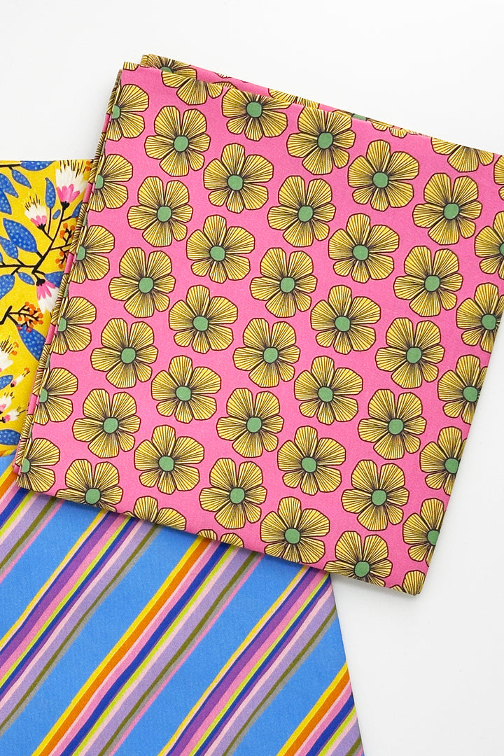 folded furoshiki wrapping cloth with pink floral print next to blue striped cloth