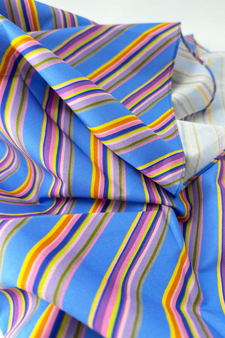 close up of furoshiki wrapping cloth showing blue fabric with multicolour diagonal stripes