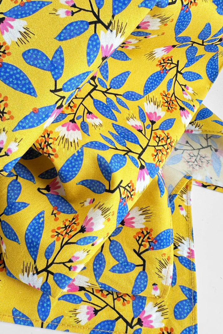 close up of furoshiki wrapping cloth showing yellow fabric with blue and pink floral pattern
