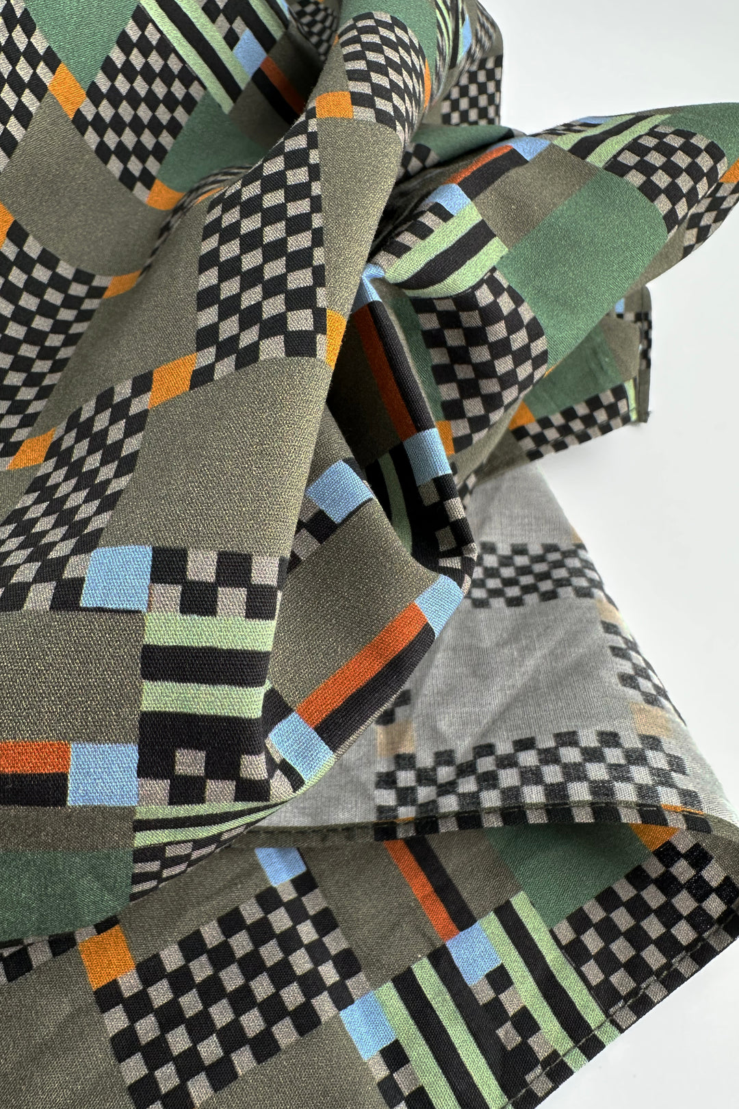 folded furoshiki wrapping cloth showing graphic check pattern with muted green and orange accents