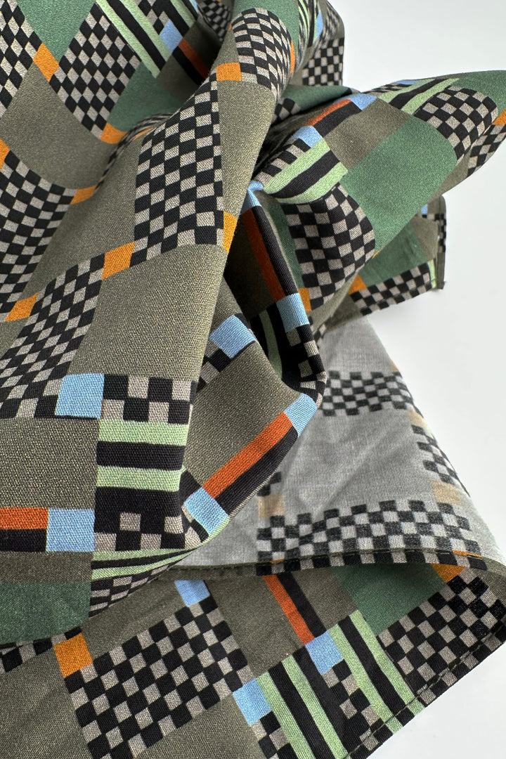 folded furoshiki wrapping cloth showing graphic check pattern with muted green and orange accents