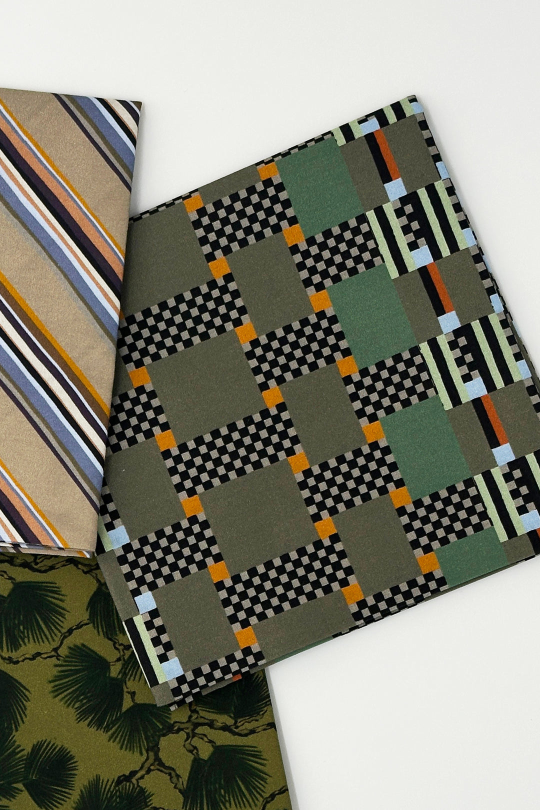 layered furoshiki wrapping cloth combining graphic check fabric with striped and botanical designs