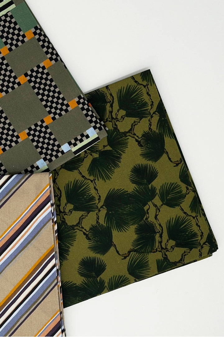 layered furoshiki fabrics combining pine print with striped and graphic designs