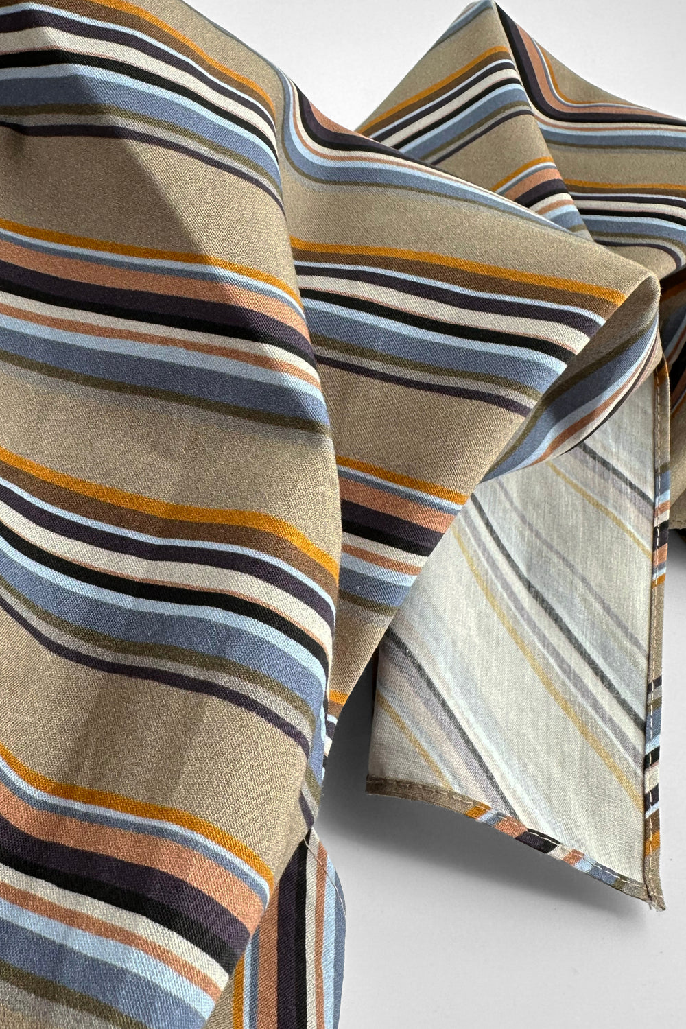folded furoshiki wrapping cloth showing neutral striped pattern in brown, blue and beige