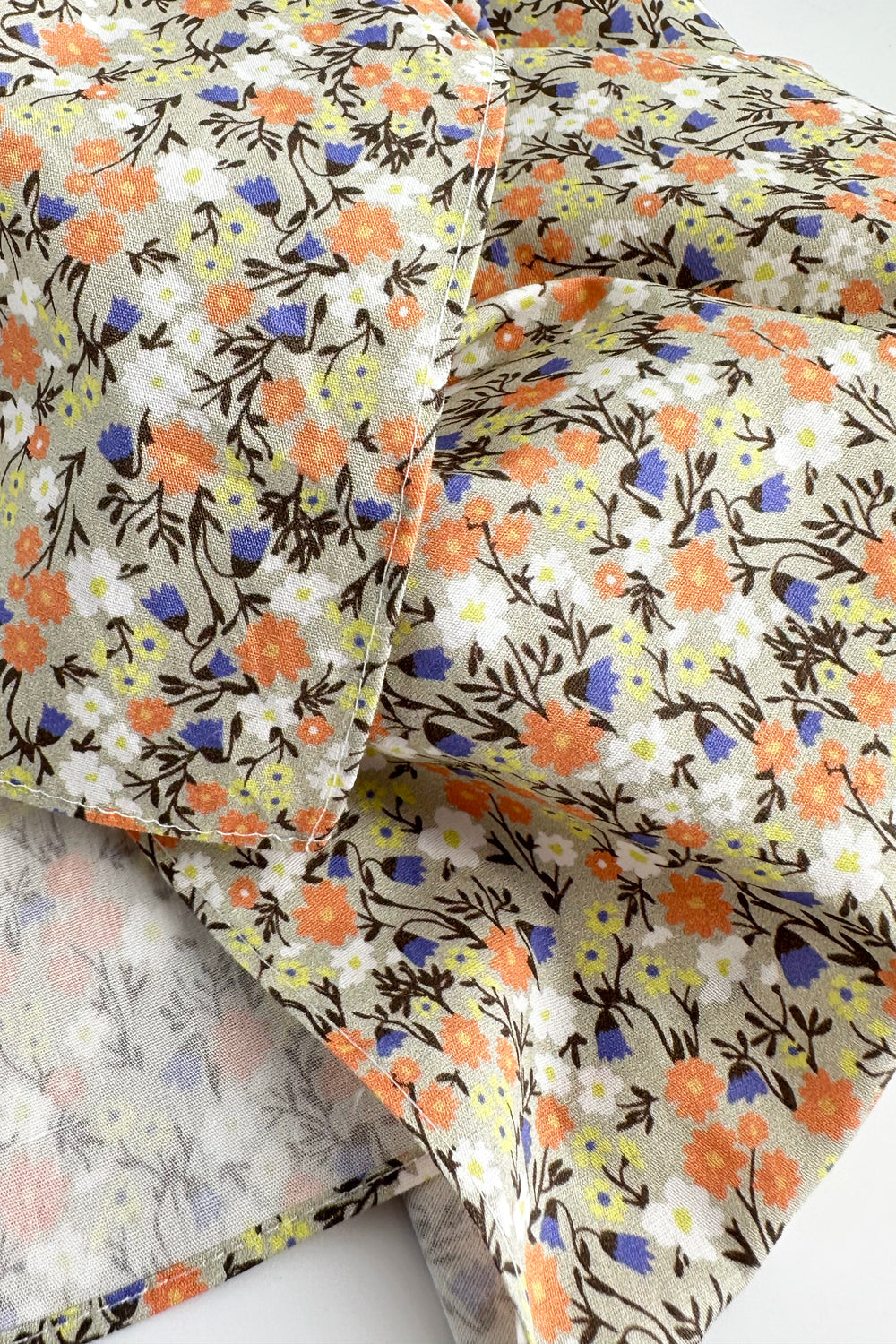 folded furoshiki fabric showing dense multicolor flower print