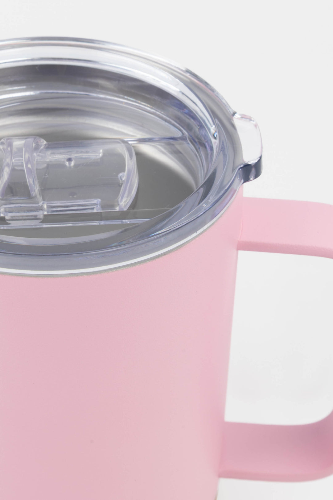 close up of clear lid and handle on pink insulated mug with cork base
