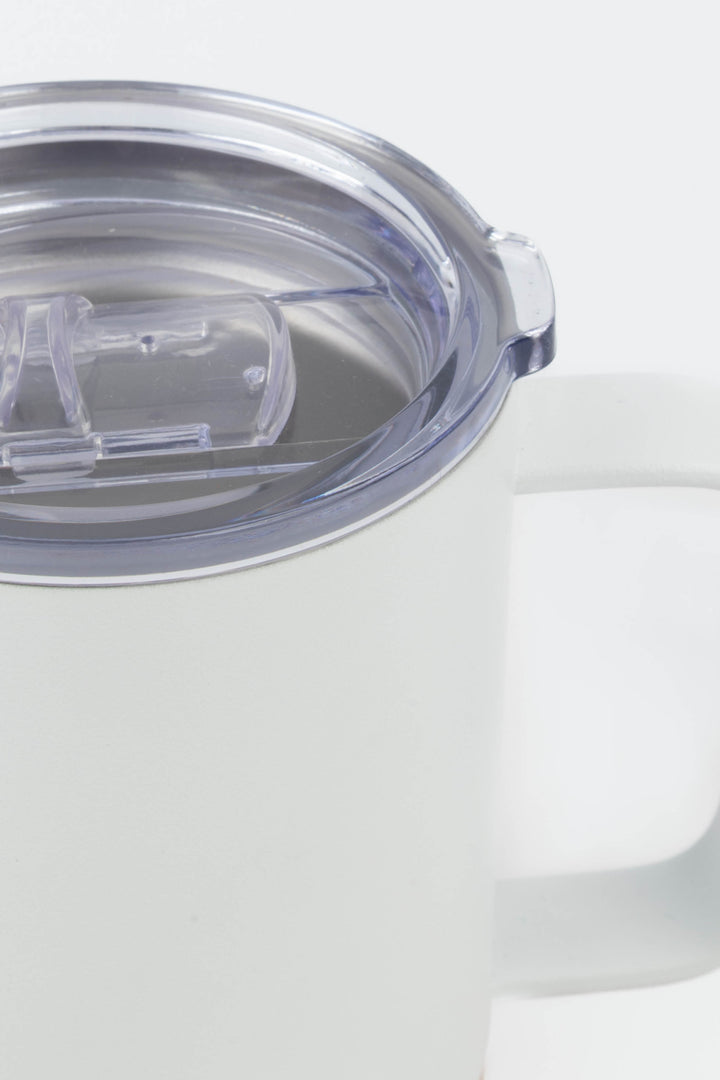 close up of clear lid and handle on white insulated mug with cork base

