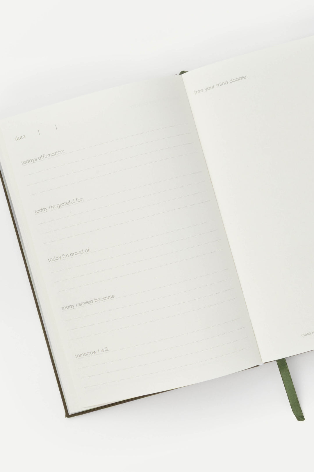 Journal opened to structured prompts, with lined pages for daily reflection and a blank doodle page on the right.