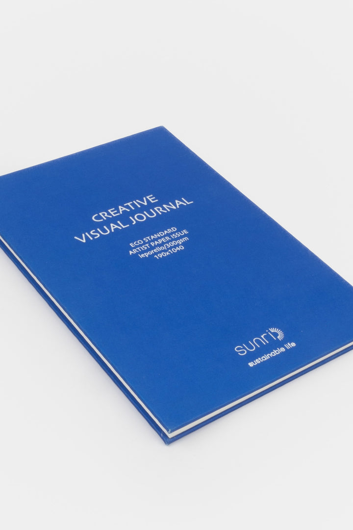 Blue 鈥楥reative Visual Journal鈥?with 鈥榮unri鈥?branding shown closed at an angle highlighting slim hardcover profile
