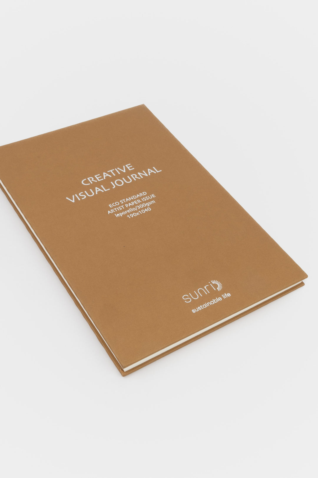 Brown journal with 'Creative Visual Journal' text on a white background