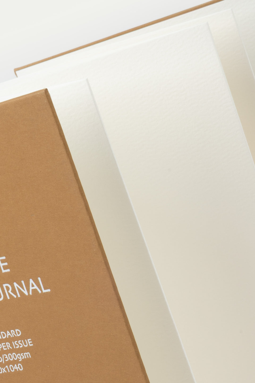 Close-up of a brown and white sketchbook with text on a light background