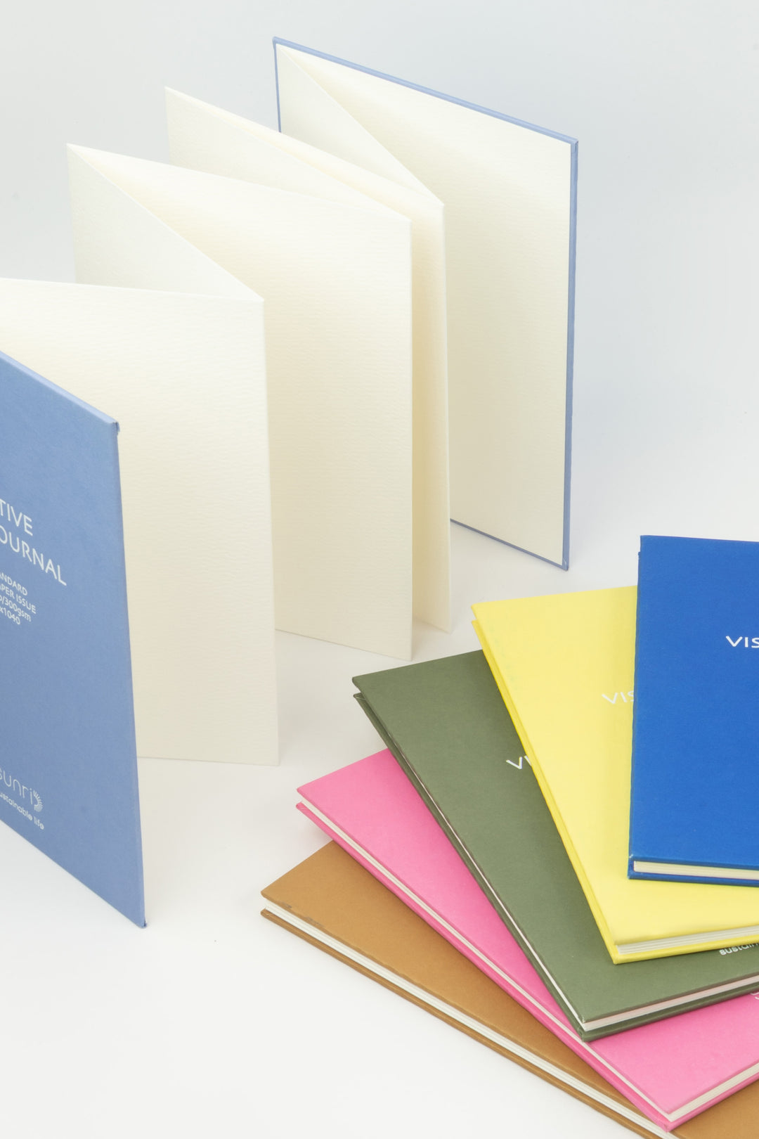 Set of colorful notebooks with visible brand name on a light background