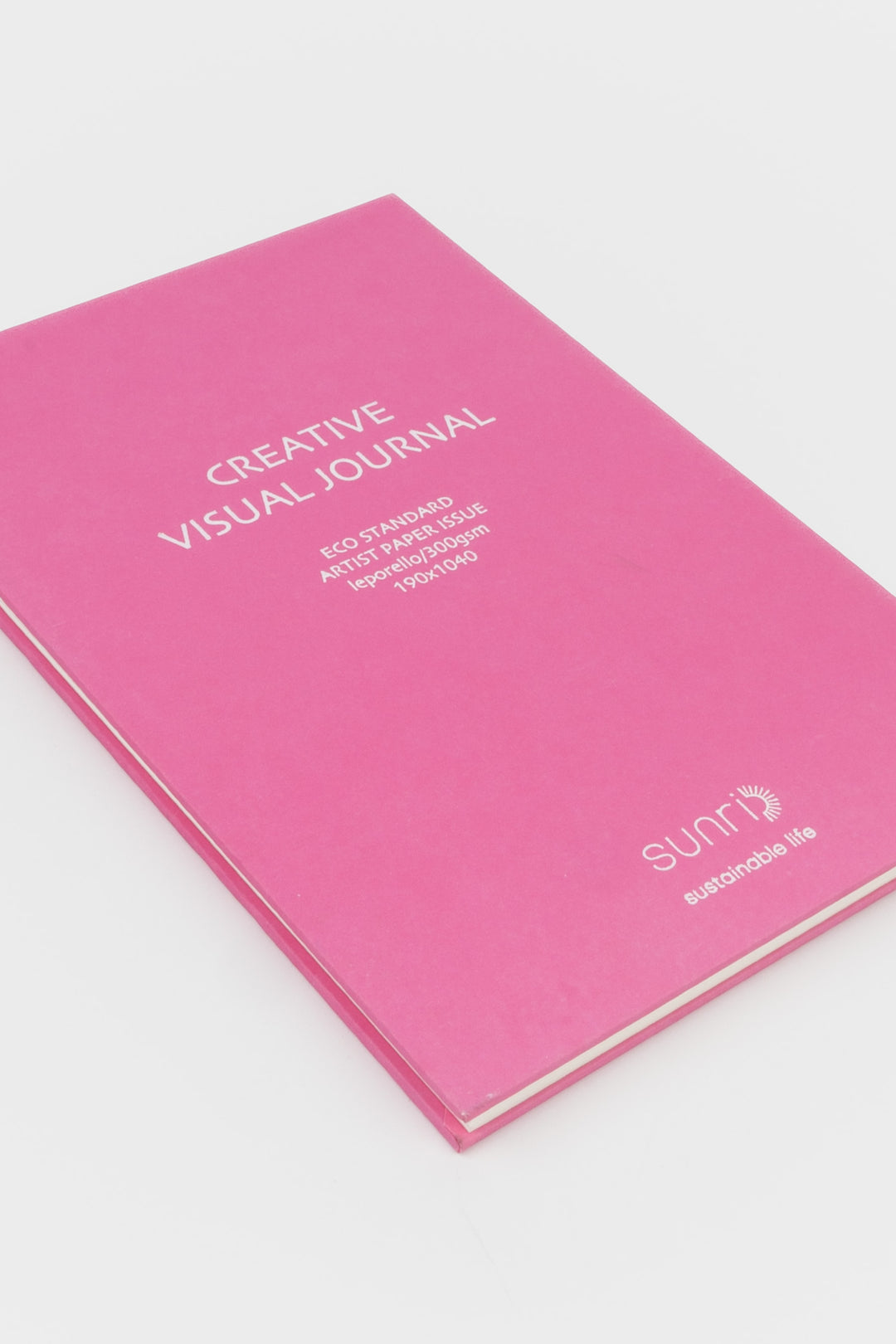 Pink journal with 'Creative Visual Journal' text on a white background