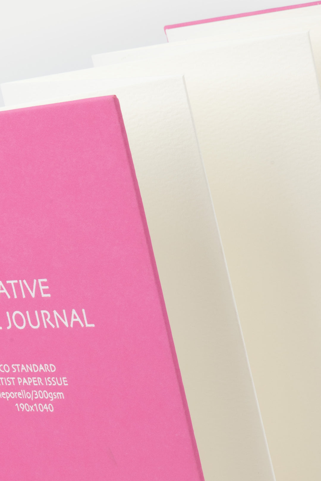 Pink and white journals on a light gray background