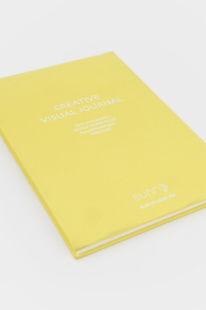 yellow 鈥楥reative Visual Journal鈥?with 鈥榮unri鈥?branding shown closed at an angle highlighting slim hardcover profile
