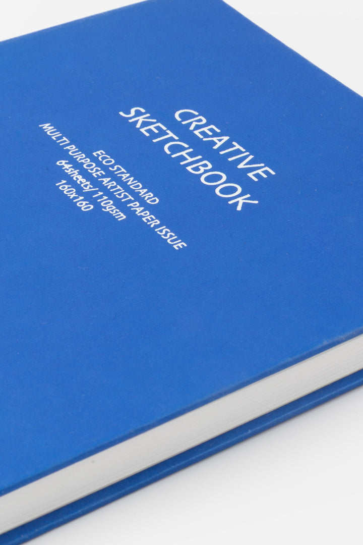 Close up of blue creative square sketchbook cover showing printed specifications and smooth hardcover texture
