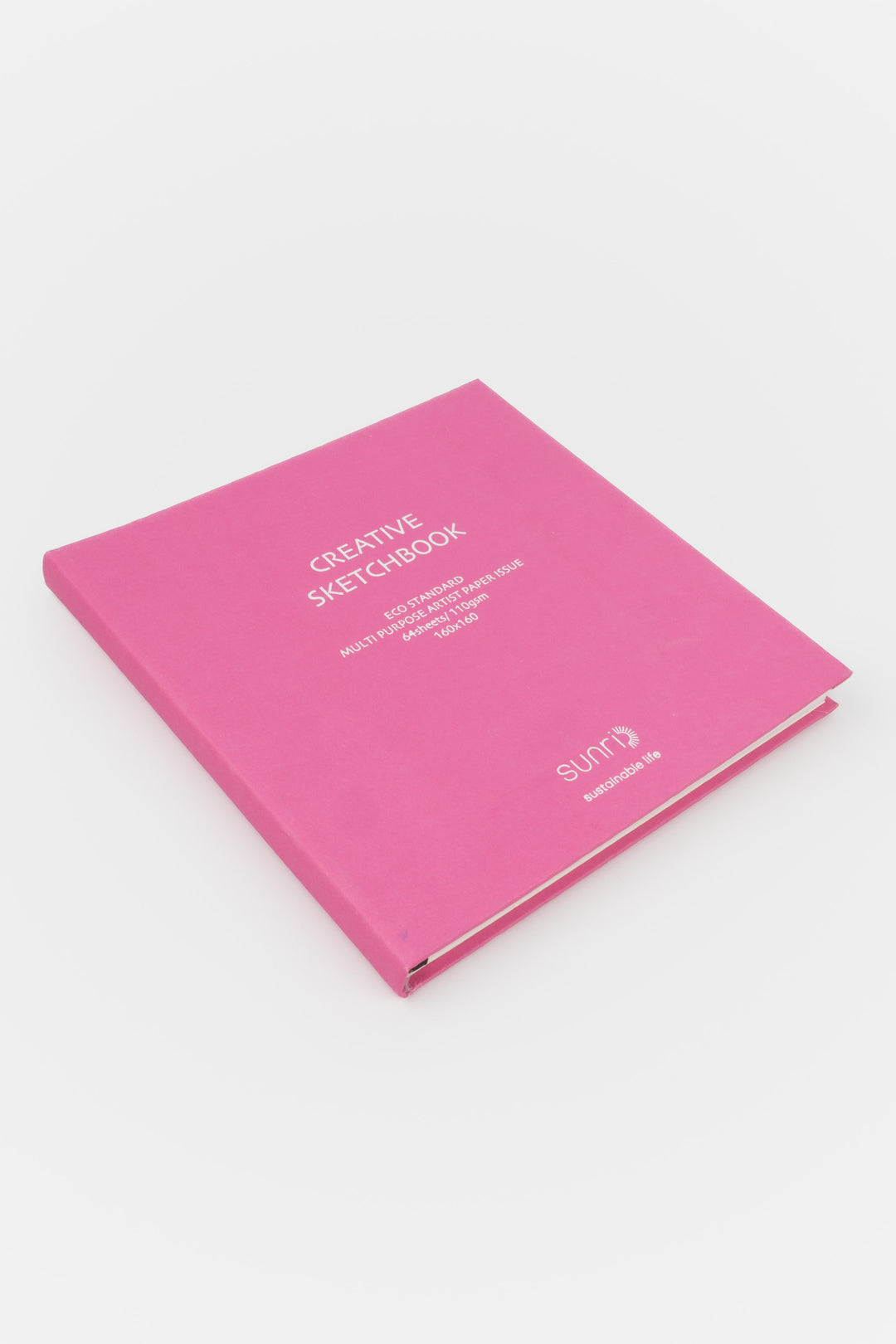 Pink notebook with 'Creative Sketchbook' text on a white background