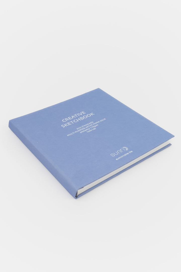 Creative square purple sketchbook with sunri branding lying closed on white background

