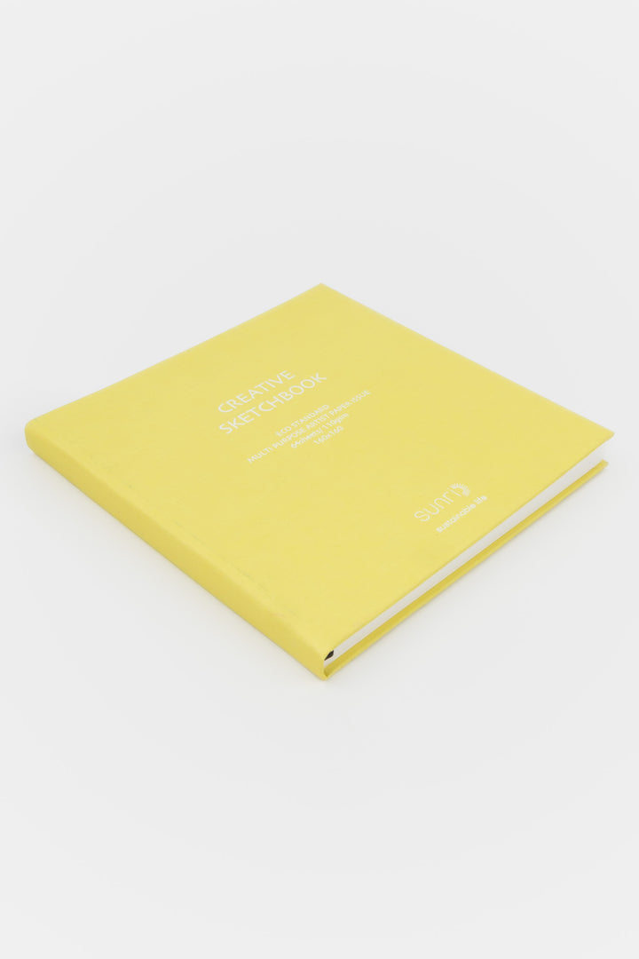 Yellow square Creative Sketchbook with white 鈥榮unri鈥?branding photographed closed on a flat white surface