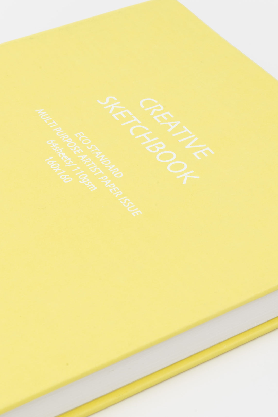 Close up of yellow square Creative Sketchbook showing white printed title and details on matte hardcover