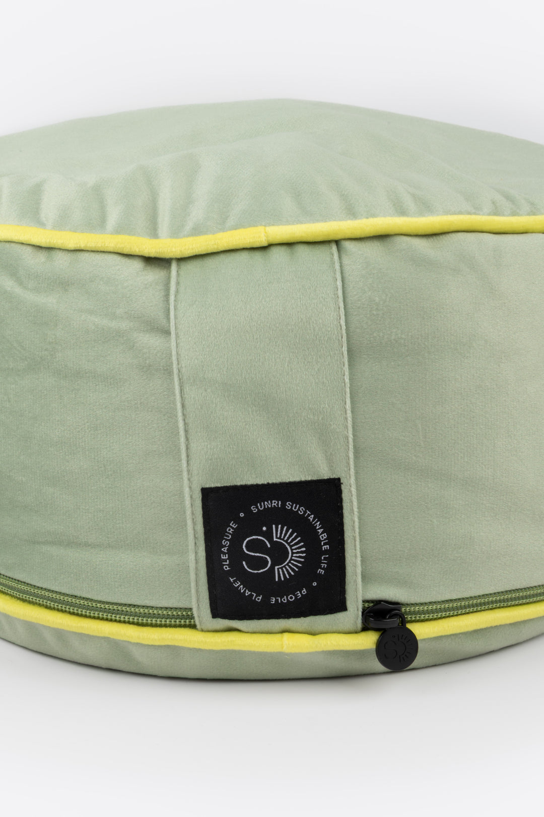 Green meditation pillow with yellow trim and a brand label on a white background