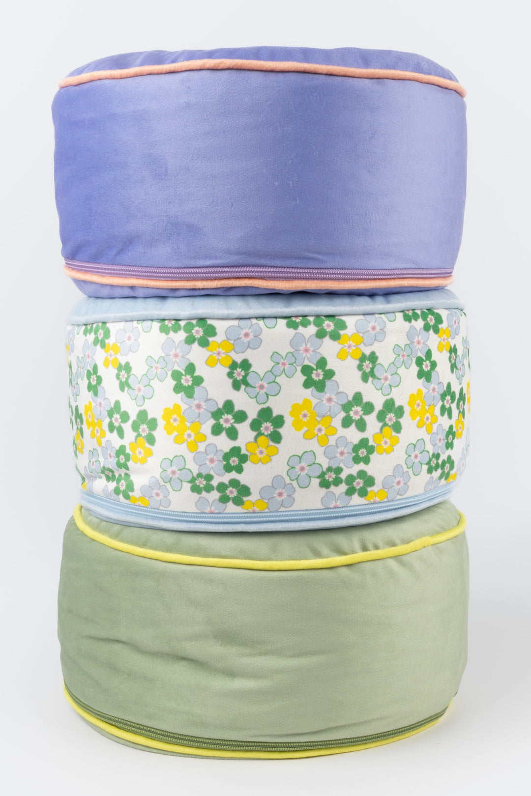 Stack of three meditation pillows with floral pattern on a white background