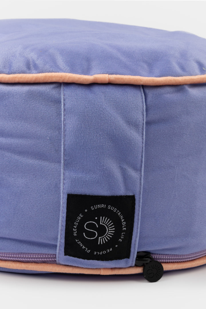 Purple meditation pillow with a brand label on a white background
