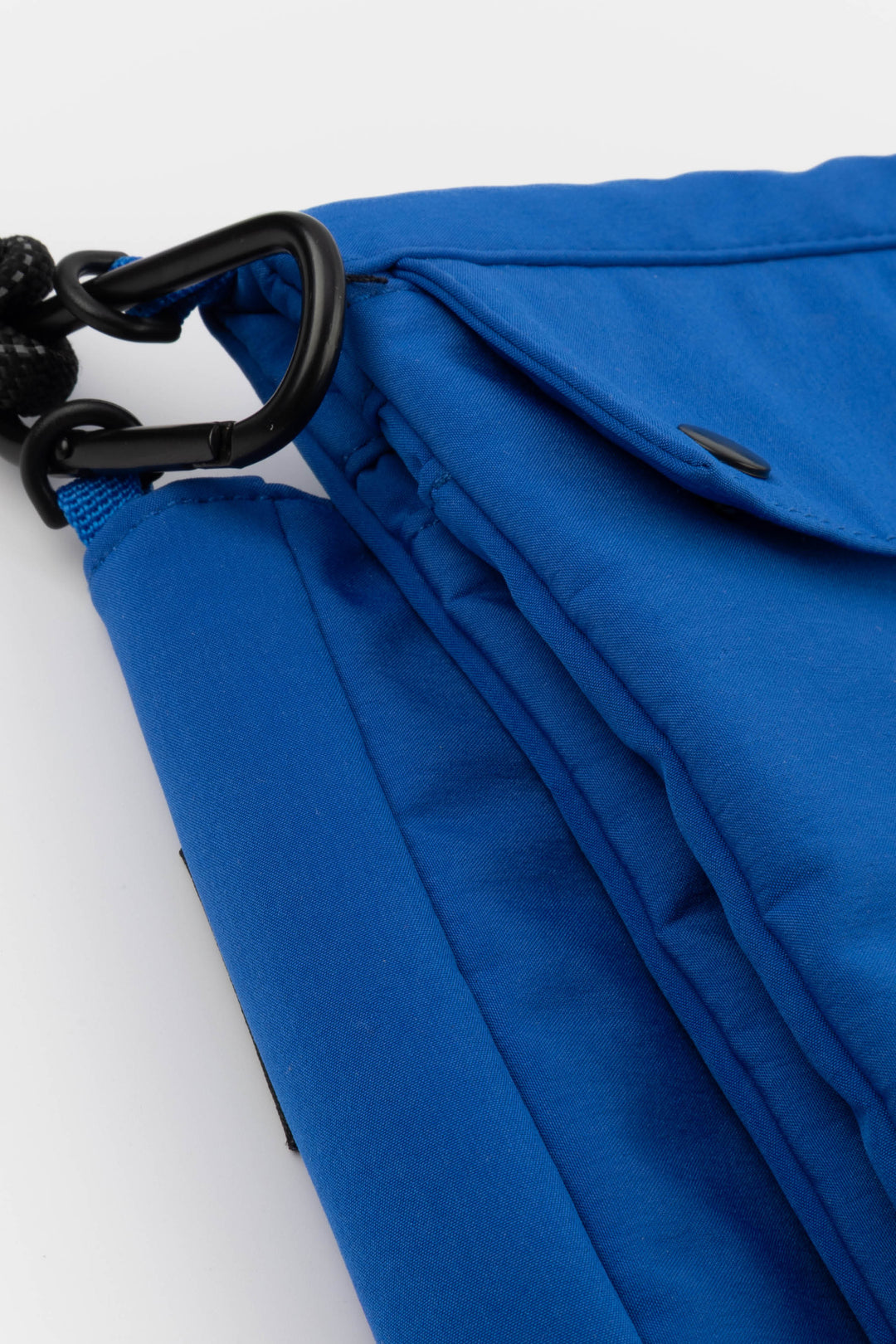 Close-up of a blue bag with a black metal clasp on a white background