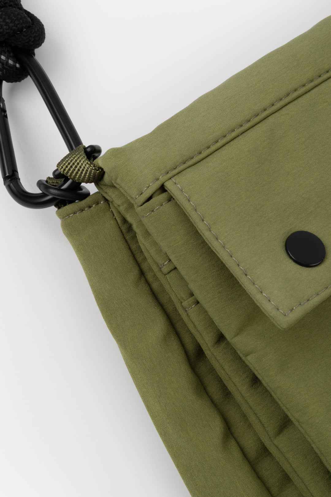 Close-up of a green bag with a carabiner on a white background