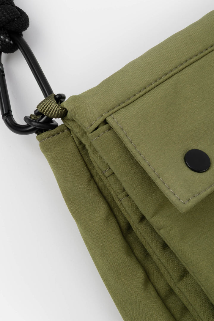 Close-up of a green bag with a carabiner on a white background